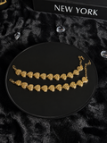 Gold-toned bracelets with textured heart-shaped links on a black display