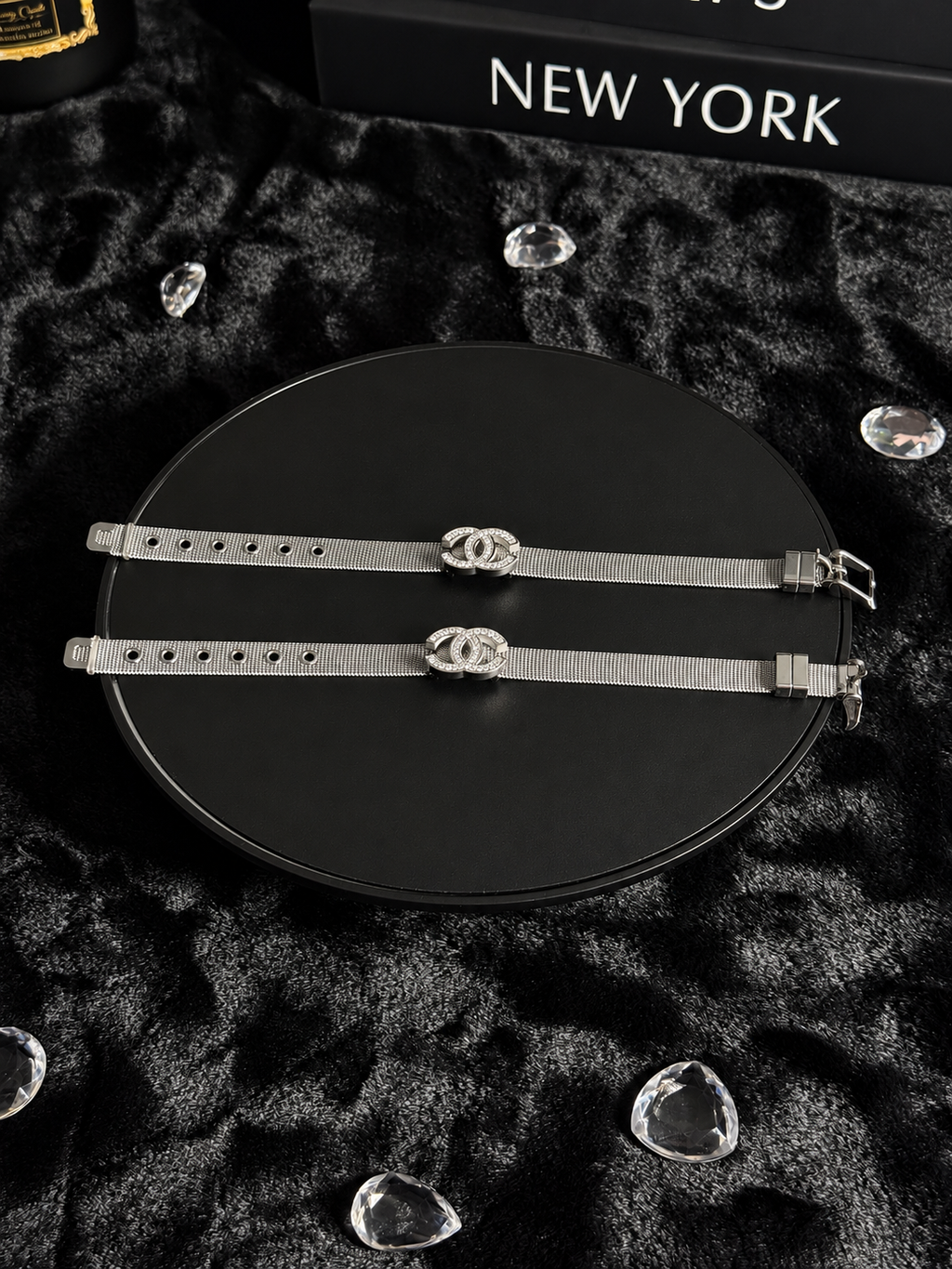 Silver-toned mesh bracelets with sparkling interlocking CC-shaped centrepieces on a black display
