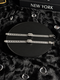 Silver-toned mesh bracelets with sparkling interlocking CC-shaped centrepieces on a black display