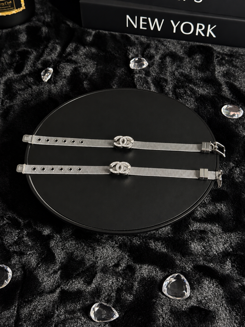 Silver-toned mesh bracelets with sparkling interlocking CC-shaped centrepieces on a black display