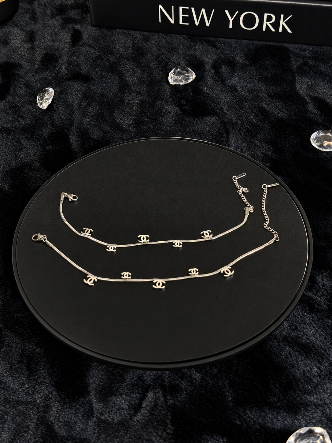 Silver-toned chains with interlocking CC-shaped charms on a black display