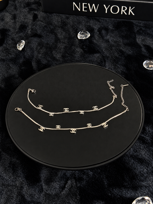 Silver-toned chains with interlocking CC-shaped charms on a black display
