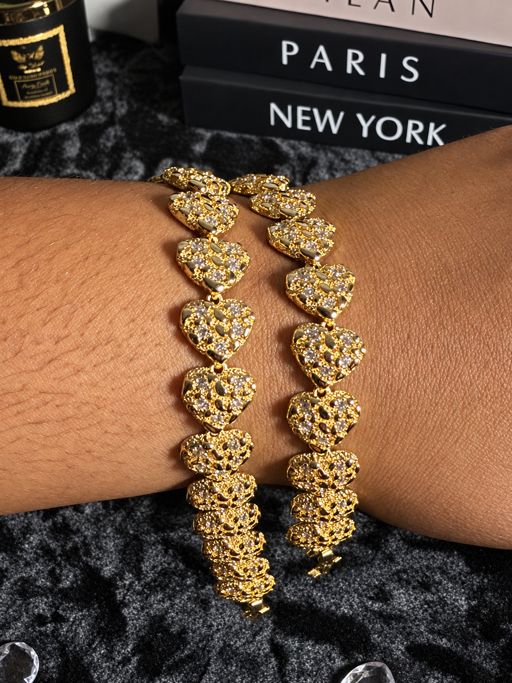 Gold-toned textured heart bracelets with sparkling accents displayed on a wrist